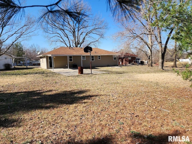 back of house with a patio and a lawn