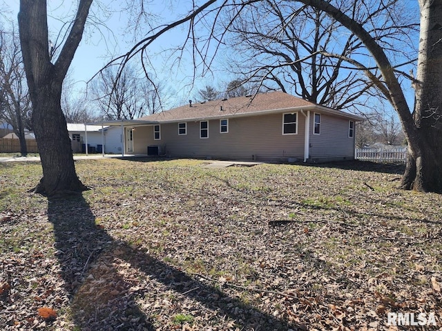 rear view of house with central AC and fence