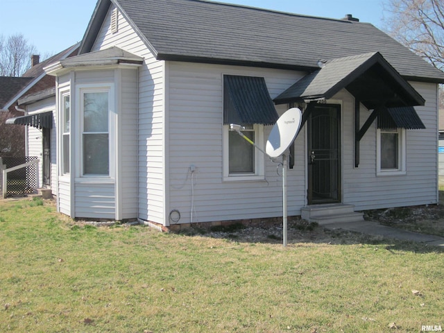 view of front of house with entry steps and a front yard