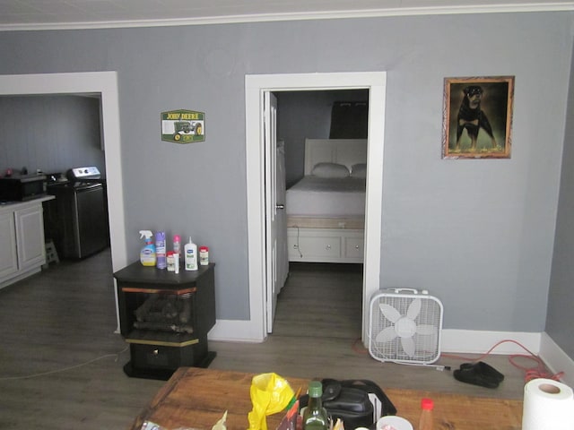 interior space featuring baseboards, separate washer and dryer, wood finished floors, and ornamental molding