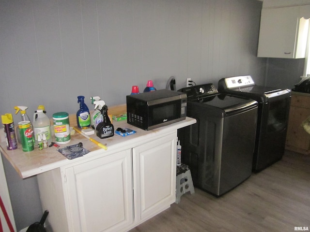 clothes washing area featuring cabinet space, washer and dryer, and light wood-style floors