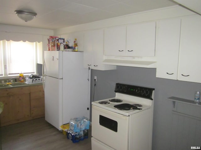 kitchen with range hood, white appliances, light wood finished floors, a sink, and white cabinets