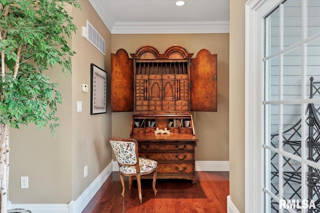 bar featuring visible vents, wood finished floors, baseboards, and ornamental molding