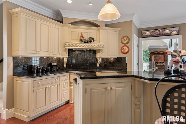 kitchen featuring ornamental molding, tasteful backsplash, cream cabinets, dark stone counters, and light wood-style floors
