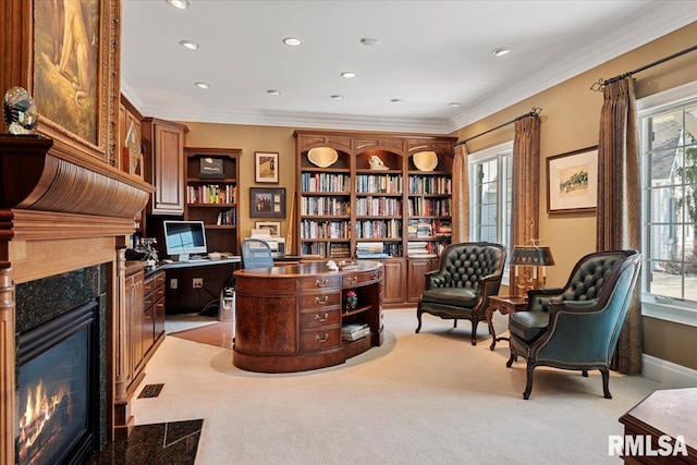 home office featuring light carpet, ornamental molding, a healthy amount of sunlight, and a premium fireplace