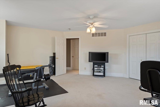 exercise area featuring light colored carpet, a ceiling fan, visible vents, and baseboards