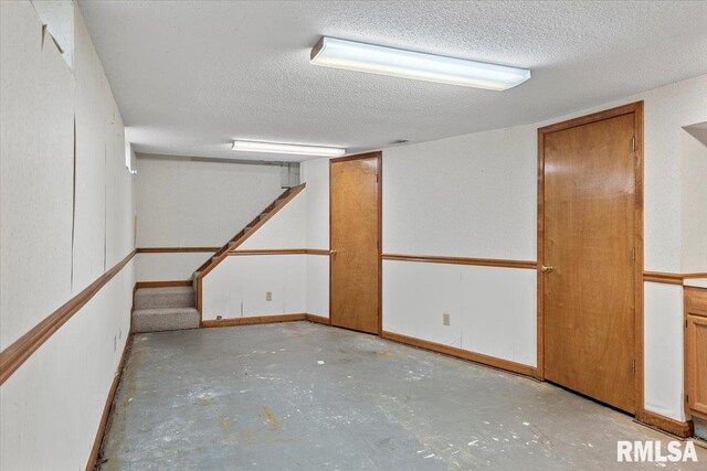 finished below grade area featuring a textured ceiling