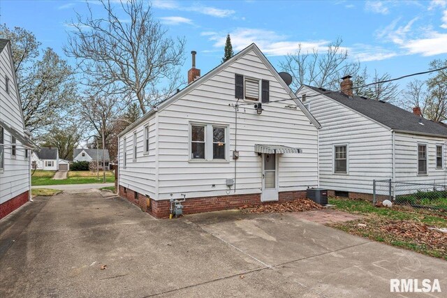 back of house with crawl space, a chimney, and fence