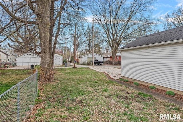 view of yard with a residential view, a storage unit, fence, and an outdoor structure