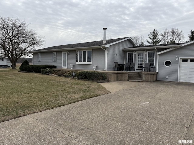 single story home with a front lawn, a garage, driveway, and a patio