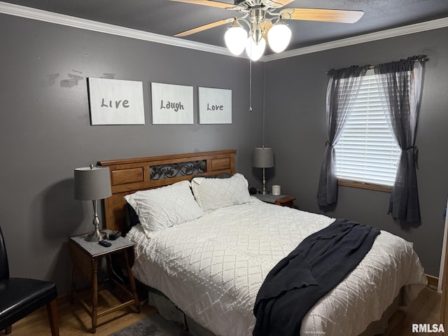 bedroom featuring ceiling fan, wood finished floors, and ornamental molding