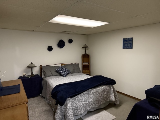 carpeted bedroom featuring a paneled ceiling and baseboards