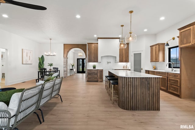 5819 Kelley Pointe Dr, Springfield, IL 62711 - kitchen with hanging light fixtures, backsplash, ceiling fan with notable chandelier, and light wood-type flooring