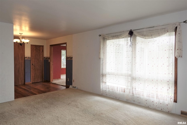 132 W Coal St, Wataga, IL 61488 - unfurnished living room featuring visible vents, carpet floors, and an inviting chandelier