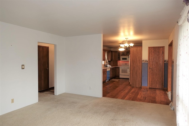 132 W Coal St, Wataga, IL 61488 - unfurnished living room featuring dark colored carpet and a chandelier