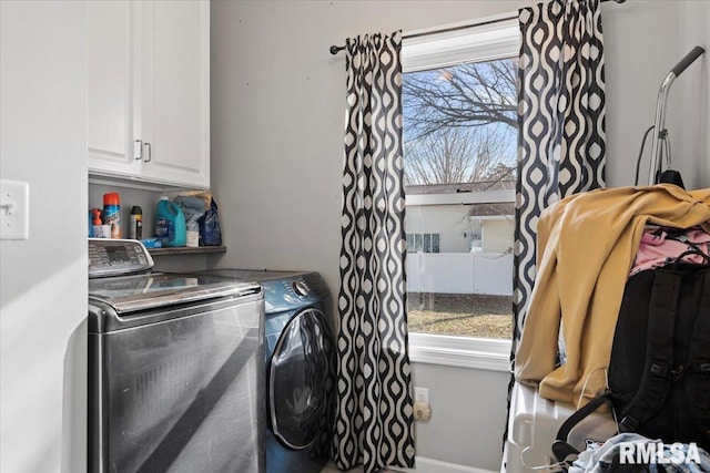 laundry area with a wealth of natural light, cabinet space, and washer and clothes dryer