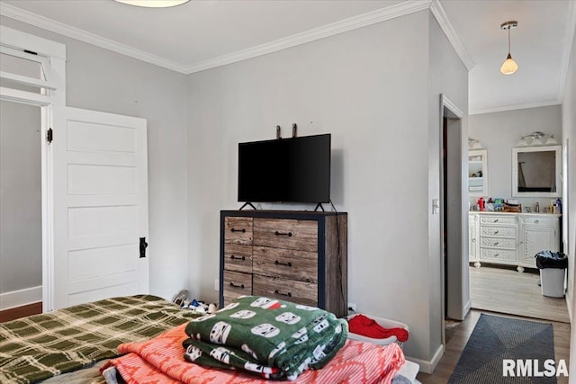 bedroom with crown molding, baseboards, and wood finished floors