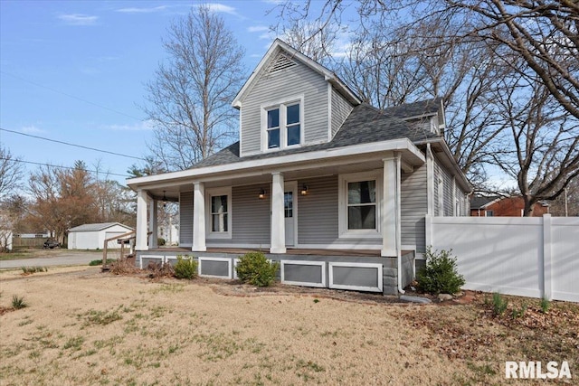 bungalow featuring a porch, fence, and roof with shingles