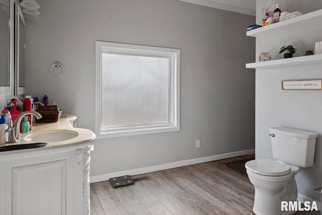 bathroom with visible vents, baseboards, wood finished floors, toilet, and vanity