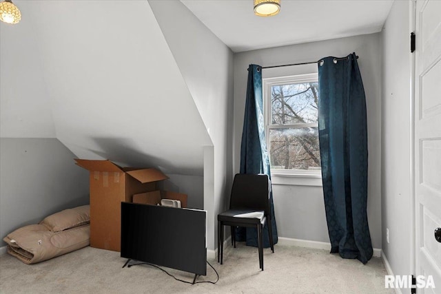 living area with baseboards, vaulted ceiling, and carpet