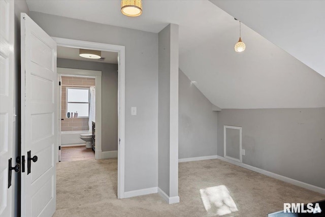 additional living space featuring light carpet, baseboards, and lofted ceiling