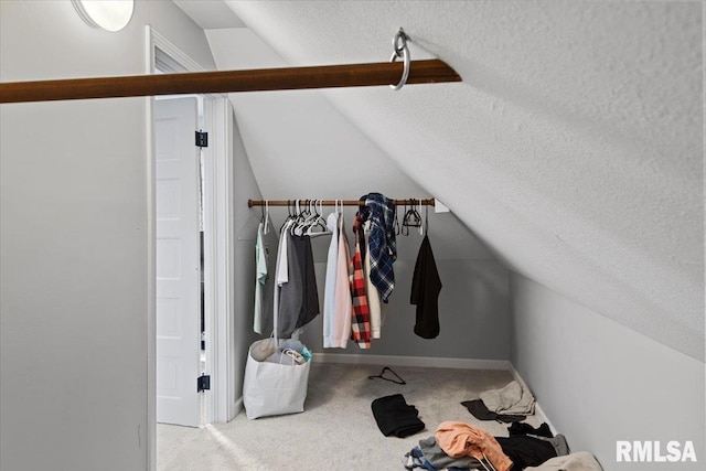 walk in closet featuring carpet and vaulted ceiling