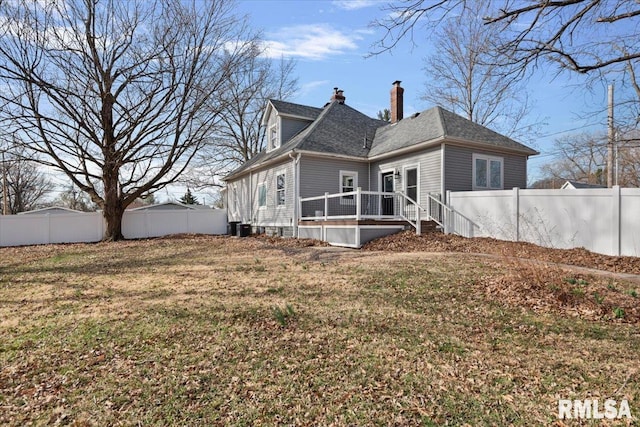 rear view of property with a fenced backyard, a lawn, and a chimney