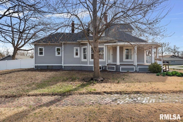 view of front of property featuring a porch, fence, and a chimney