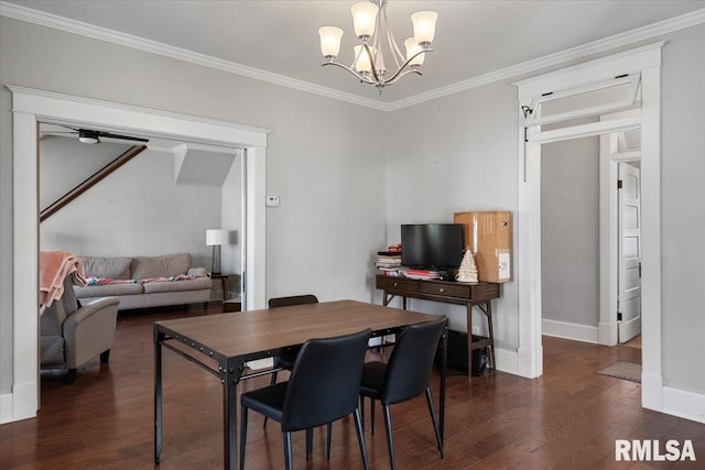 dining room with dark wood-style flooring, a notable chandelier, crown molding, and baseboards