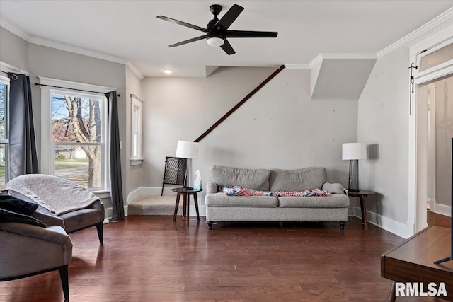 living area with baseboards, a ceiling fan, crown molding, and dark wood finished floors