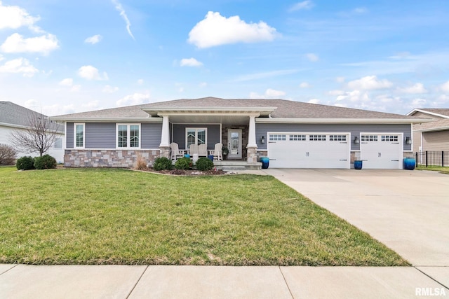 view of front of home featuring concrete driveway, stone siding, a front yard, a porch, and a garage