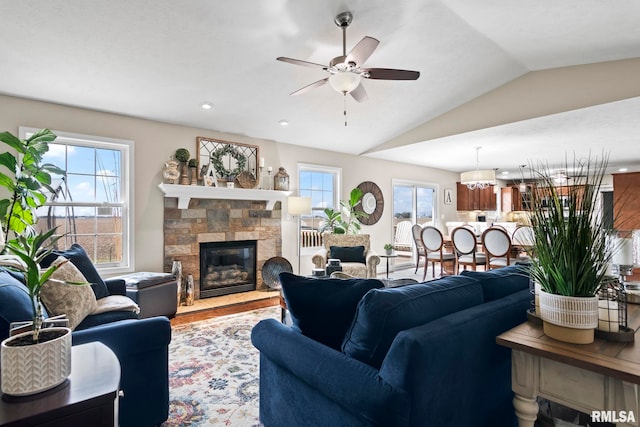 living room with a fireplace, lofted ceiling, ceiling fan, and a wealth of natural light