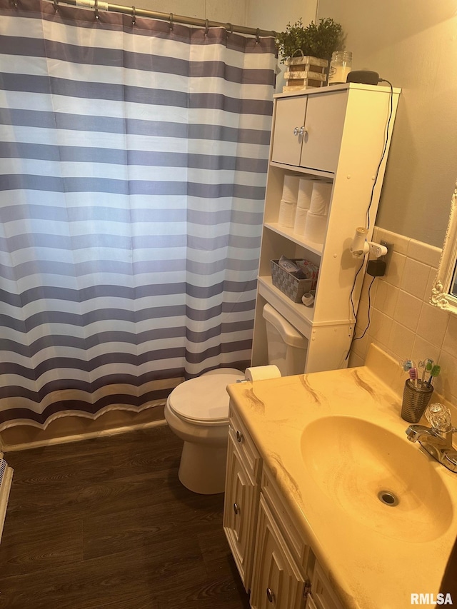 bathroom featuring wood finished floors, toilet, vanity, tile walls, and a shower with shower curtain
