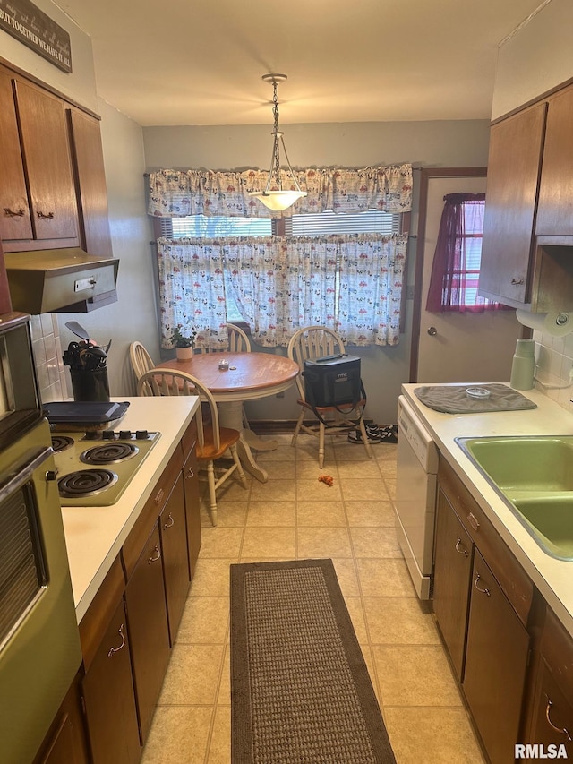 kitchen featuring wall oven, light countertops, electric stovetop, dishwasher, and hanging light fixtures