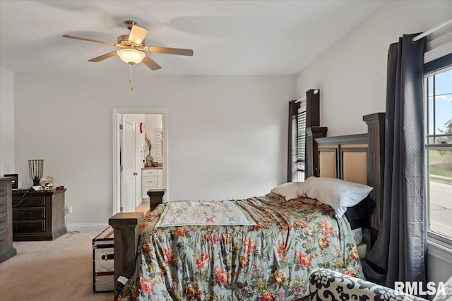carpeted bedroom with ensuite bathroom, baseboards, and a ceiling fan
