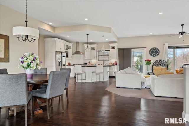 dining room with recessed lighting, plenty of natural light, ceiling fan with notable chandelier, and dark wood finished floors