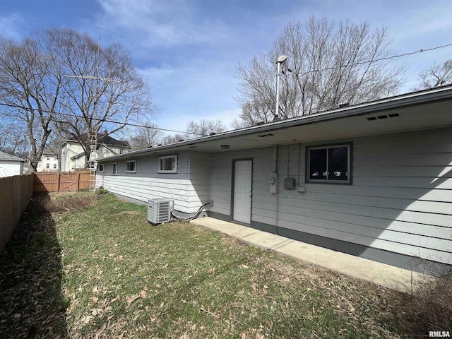 back of house featuring a yard, fence, and central AC
