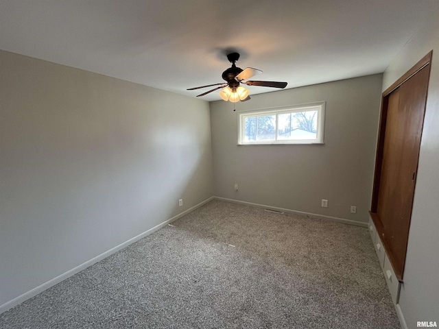 unfurnished bedroom featuring a closet, baseboards, a ceiling fan, and carpet floors