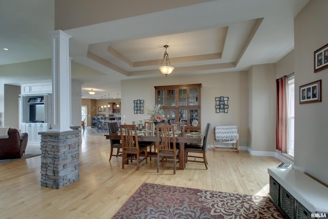 3337 Hunter Rd, Quincy, IL 62305 - dining space featuring ornate columns, wood finished floors, a raised ceiling, and baseboards