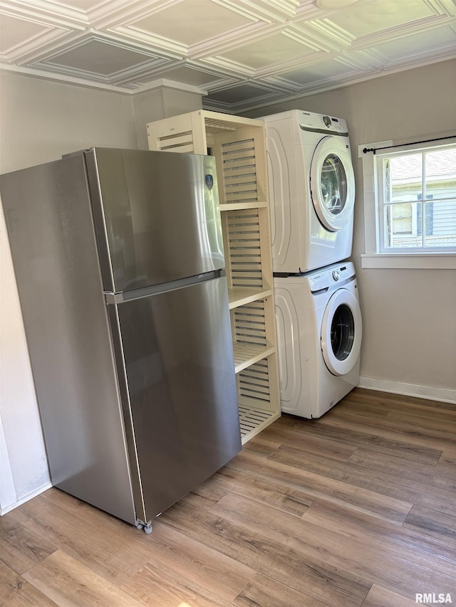 841 S 16th St, Quincy, IL 62301 - washroom with stacked washer and clothes dryer, an ornate ceiling, and light wood-type flooring