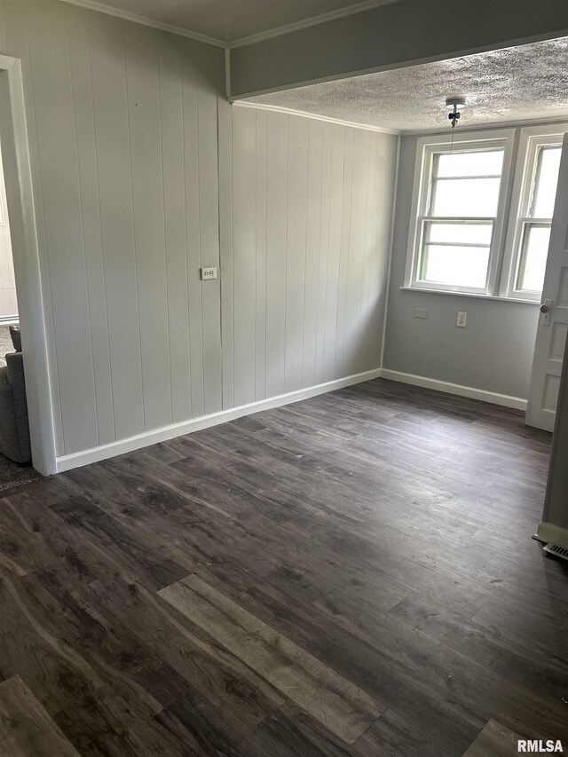 unfurnished room featuring baseboards, a textured ceiling, and dark wood finished floors