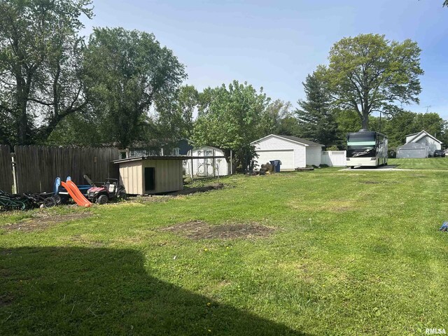 view of yard with fence, an outbuilding, a shed, and a garage
