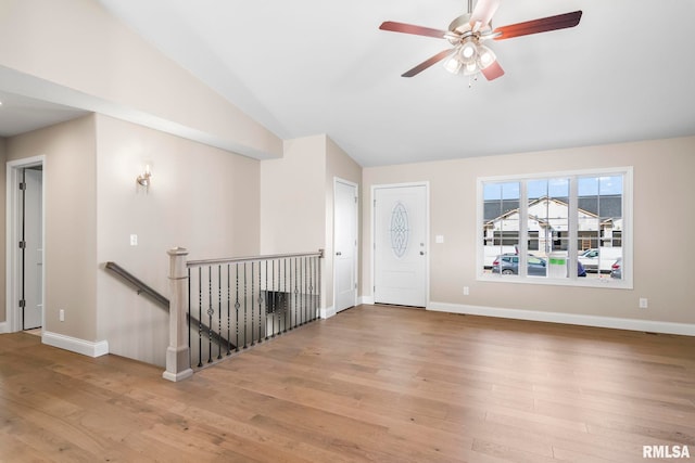 4602 Castle Pines Dr, Springfield, IL 62711 - unfurnished living room with vaulted ceiling, ceiling fan, light wood-style flooring, a glass covered fireplace, and baseboards