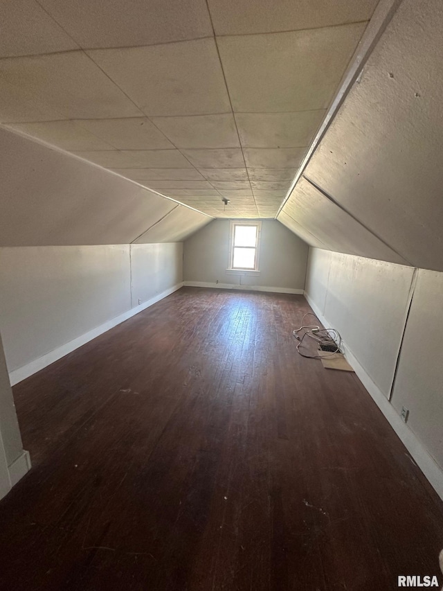 additional living space featuring vaulted ceiling, hardwood / wood-style flooring, and baseboards