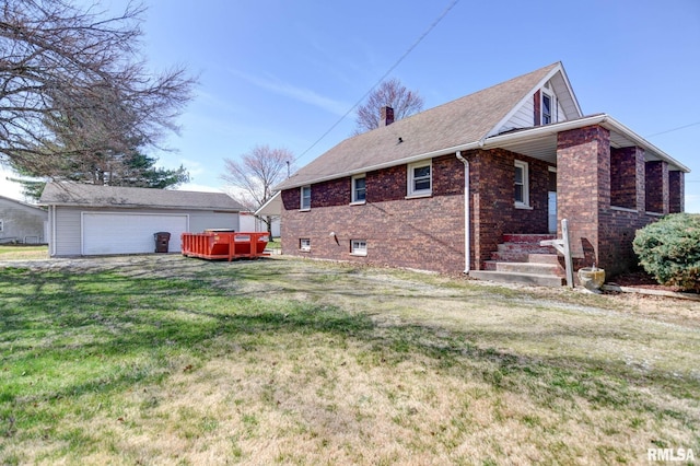 view of side of home featuring a chimney, a yard, brick siding, a hot tub, and a detached garage