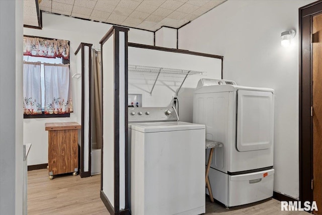 laundry room with light wood-style floors and washing machine and clothes dryer
