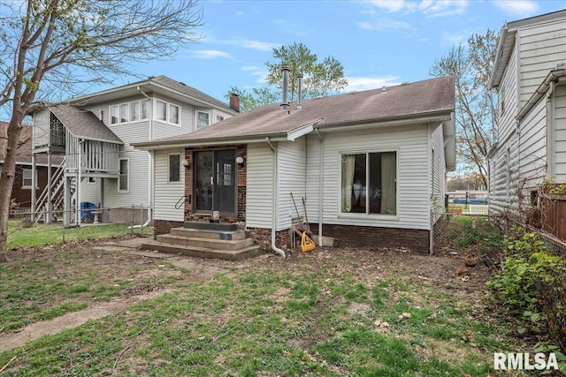 rear view of house with a fenced backyard and entry steps