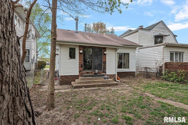 back of property with fence and entry steps