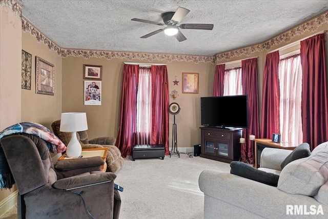 carpeted living area with a textured ceiling, baseboards, and a ceiling fan