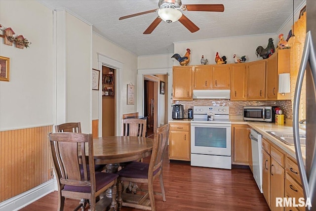 kitchen with light countertops, dishwasher, stainless steel microwave, under cabinet range hood, and white range with electric stovetop